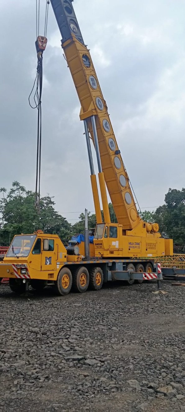 Grove hydraulic telescopic boom truck crane in Malik Crane Services livery, parked at a yard