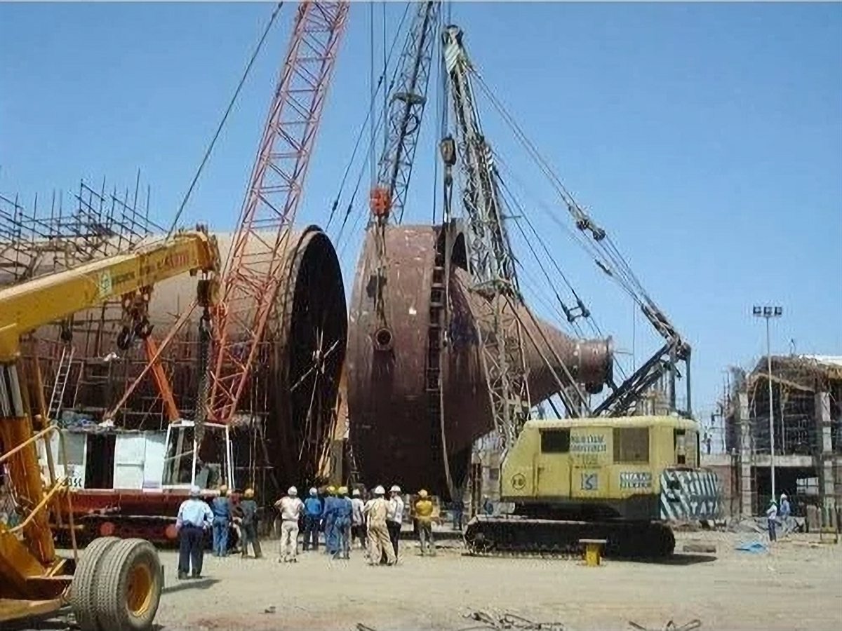Crawler cranes erecting a large pressure vessel at an industrial site